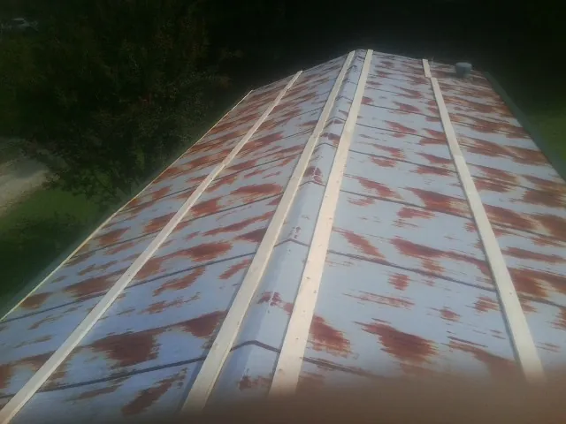 Rusted metal roof panels with new wood purlins before replacement — Storm Damage Roof Repair in Benedict by Roofing Brothers